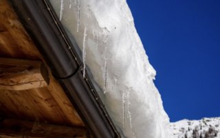 Formation de glace et accumulation de neige sur la toiture de maison. Déneigement et Déglaçage de toiture effectué par nos spécialistes